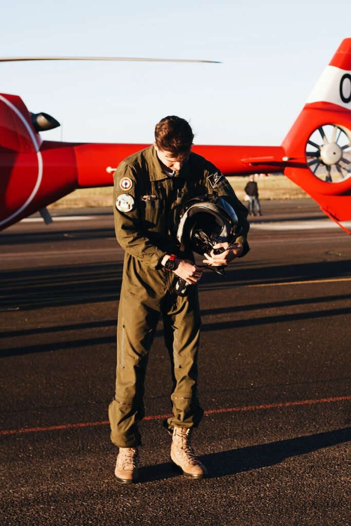 a man standing in front of a red helicopter